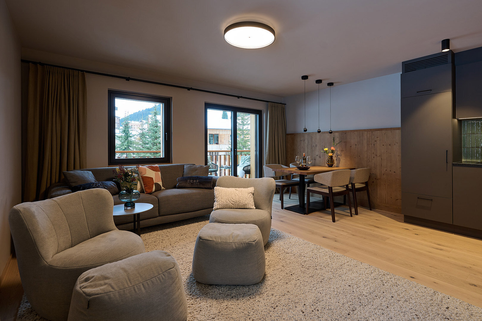 Helles Wohnzimmer mit gemütlicher Sitzecke, Essbereich, moderner Küche und Blick auf die Berge