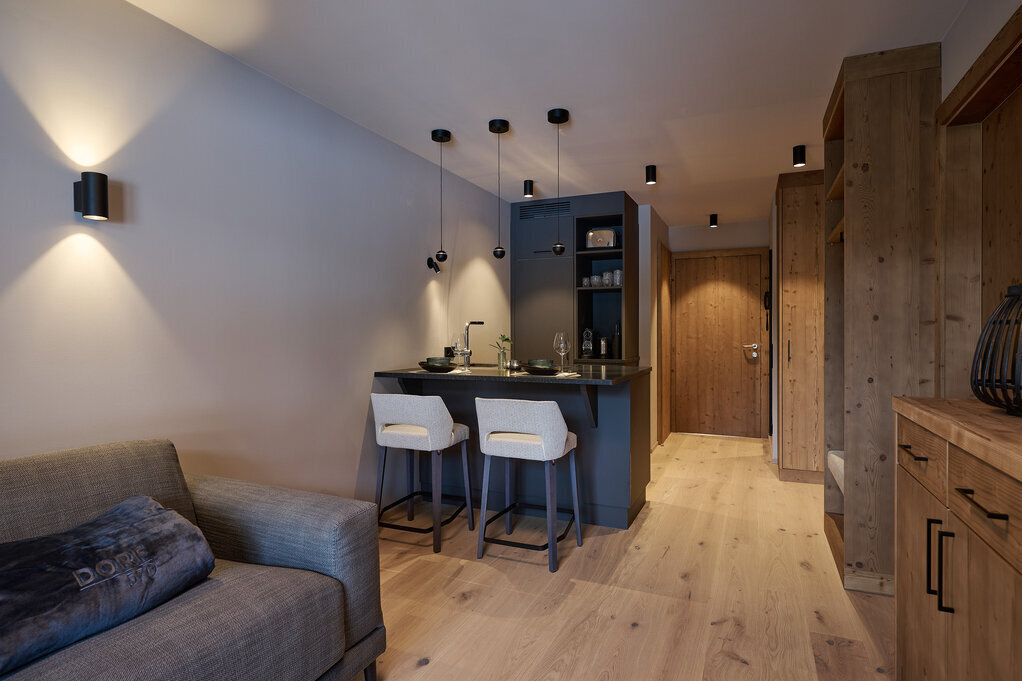 Gemütliche Ferienwohnung mit Küchenzeile, Essbereich, Holzakzenten und moderner Beleuchtung.